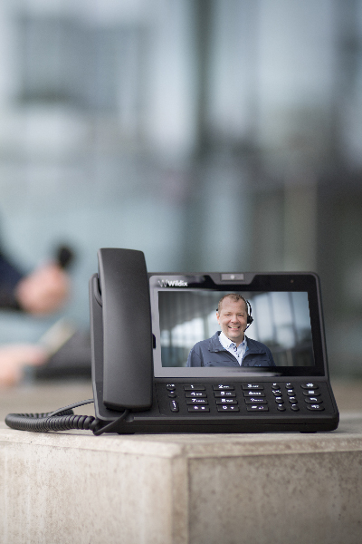 Zu sehen ist ein Bild des Geschäftsführers Stefan Katzinger auf einer Telefonanlage